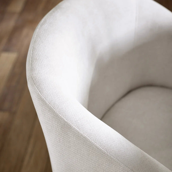 Close-up of a beige upholstered chair on a wooden floor
