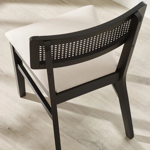 Chair with black woven backrest and white cushion on a light wooden floor.