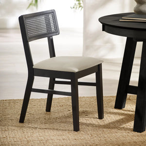 BLACK DINING CHAIR WITH WHITE SEAT AROUND A BLACK TABLE ON A TEXTURED FLOOR