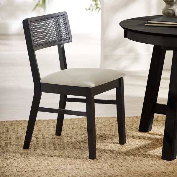 BLACK DINING CHAIR WITH WHITE SEAT AROUND A BLACK TABLE ON A TEXTURED FLOOR