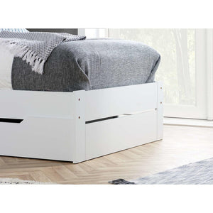 White bed frame with storage drawers in a room with light wood flooring and a window.