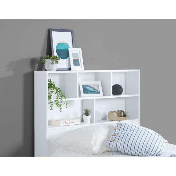 White bookshelf headboard with decorative items against a gray wall