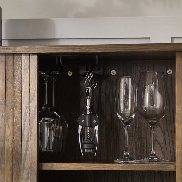 Wine glasses and a corkscrew on a wooden shelf