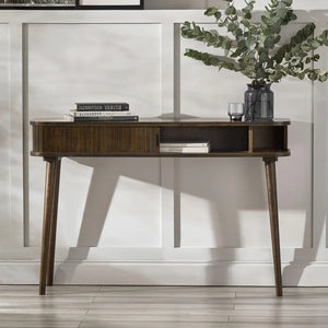 Wooden desk with books and a plant in a modern interior setting