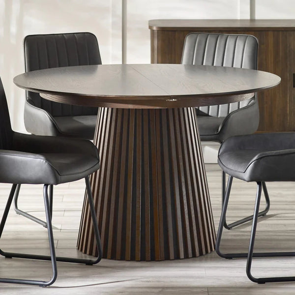 Round dining table with a striped base in a modern room setting