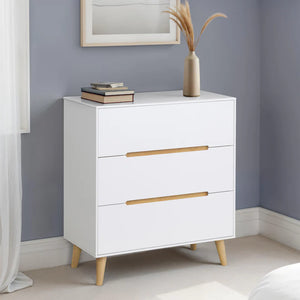 White dresser with gold handles against a gray wall