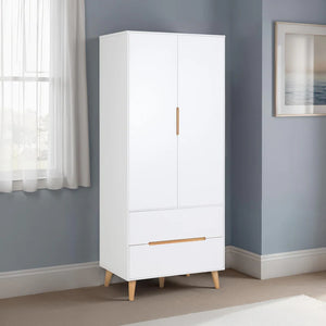 White wardrobe with wooden legs in a room with gray walls and a window.