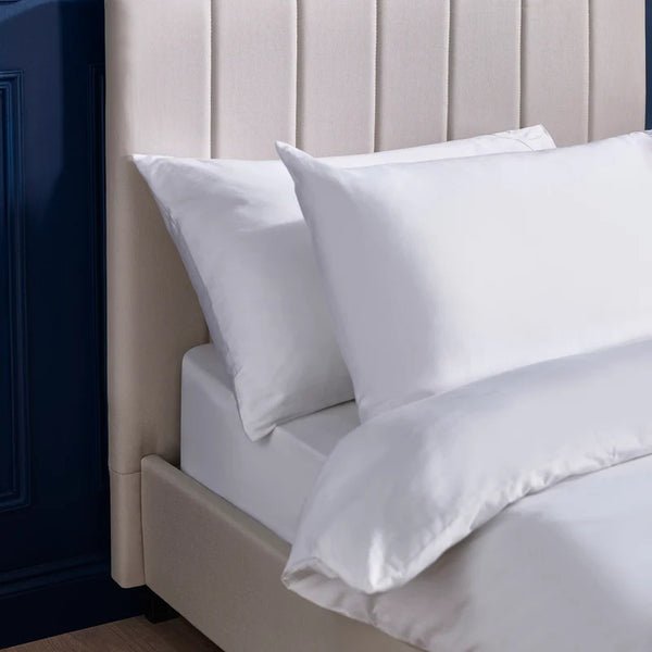 White pillows on a bed with a neutral headboard