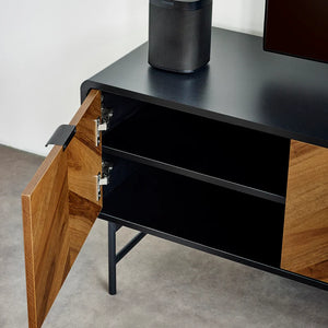 Black and wood TV stand with open cabinet door, Sonos speaker on top.