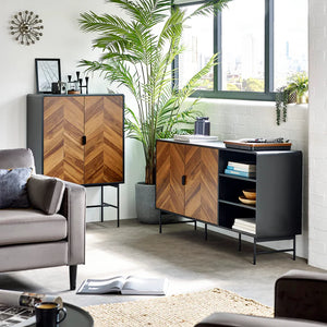 Modern living room with wooden and black furniture, plants, and a cityscape view.