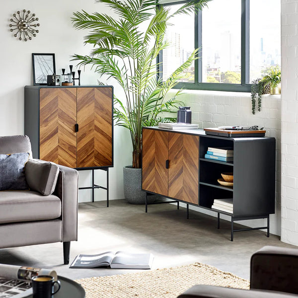 Modern living room with wooden and black furniture, plants, and a cityscape view.