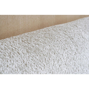 Close-up of textured white fabric on a beige background