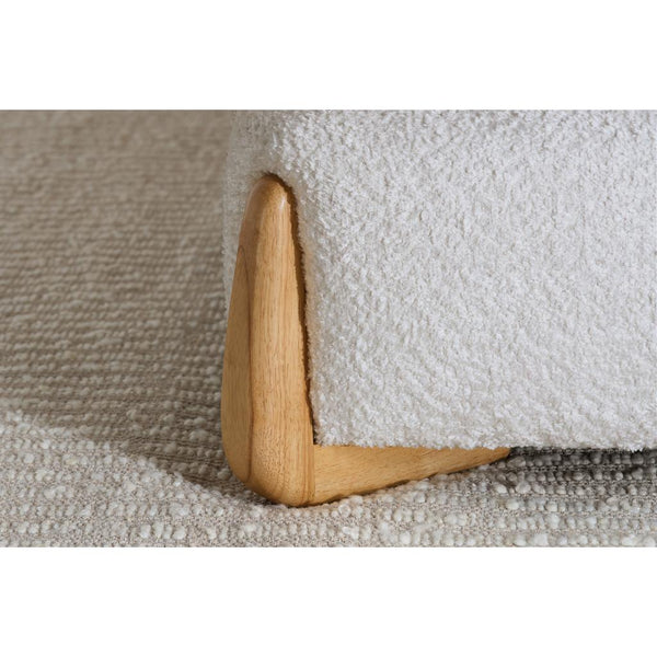 Wooden L-shaped bed frame foot on a textured surface