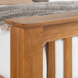 Close-up of a wooden bench with a plaid blanket on top