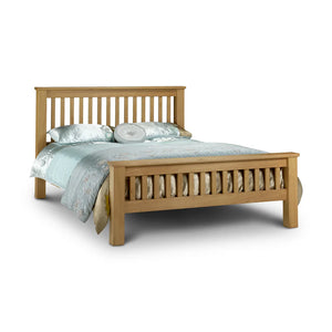 Wooden bed with light blue bedding on a white background