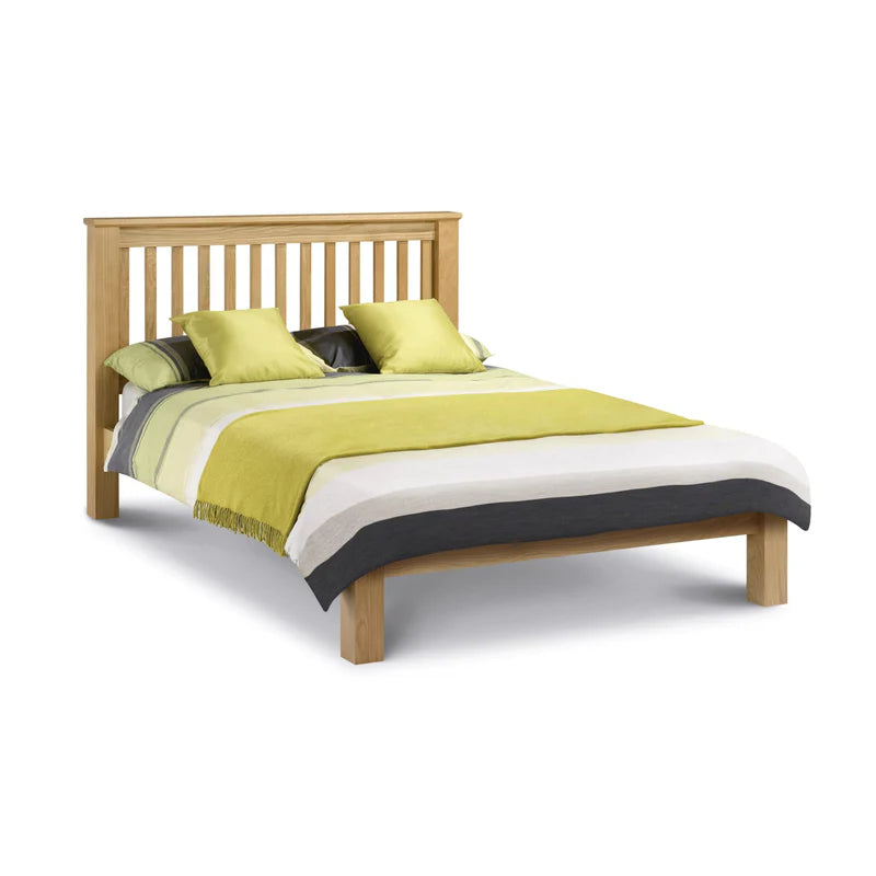 Wooden bed with green and white bedding on a white background