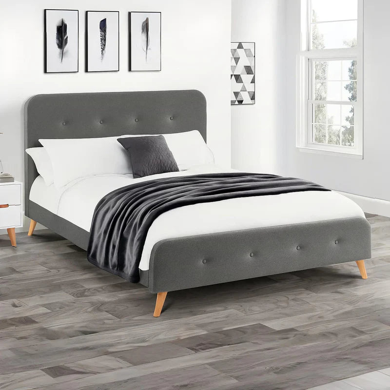 Gray upholstered bed with a white mattress on a white background