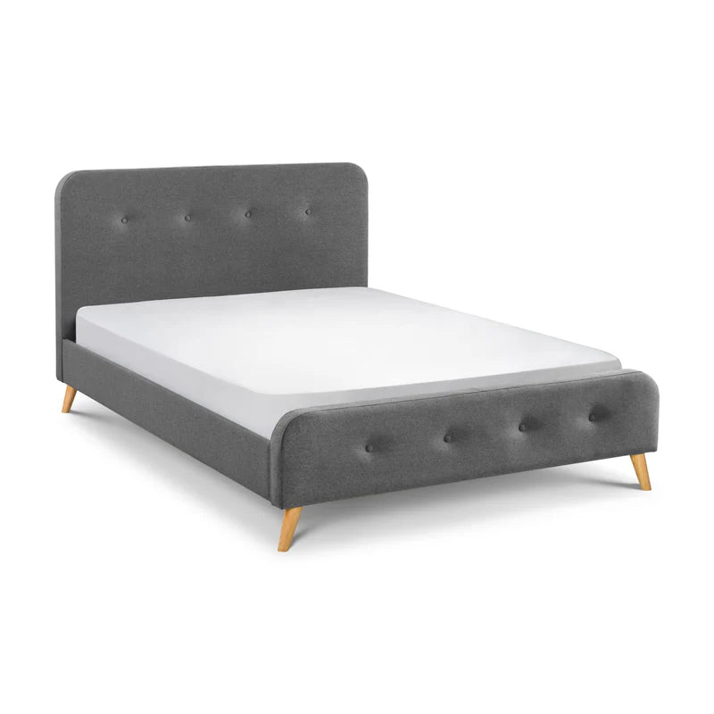 Gray upholstered bed with a white mattress on a white background
