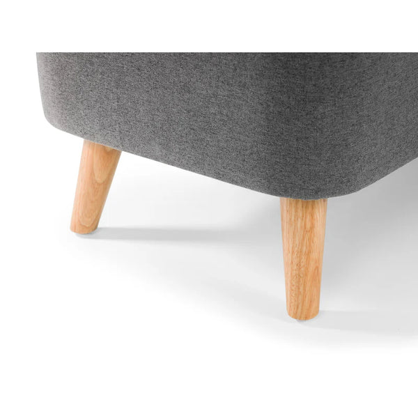 Grey upholstered ottoman with wooden legs on a white background