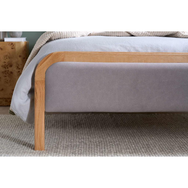Gray bed with wooden frame on a textured surface