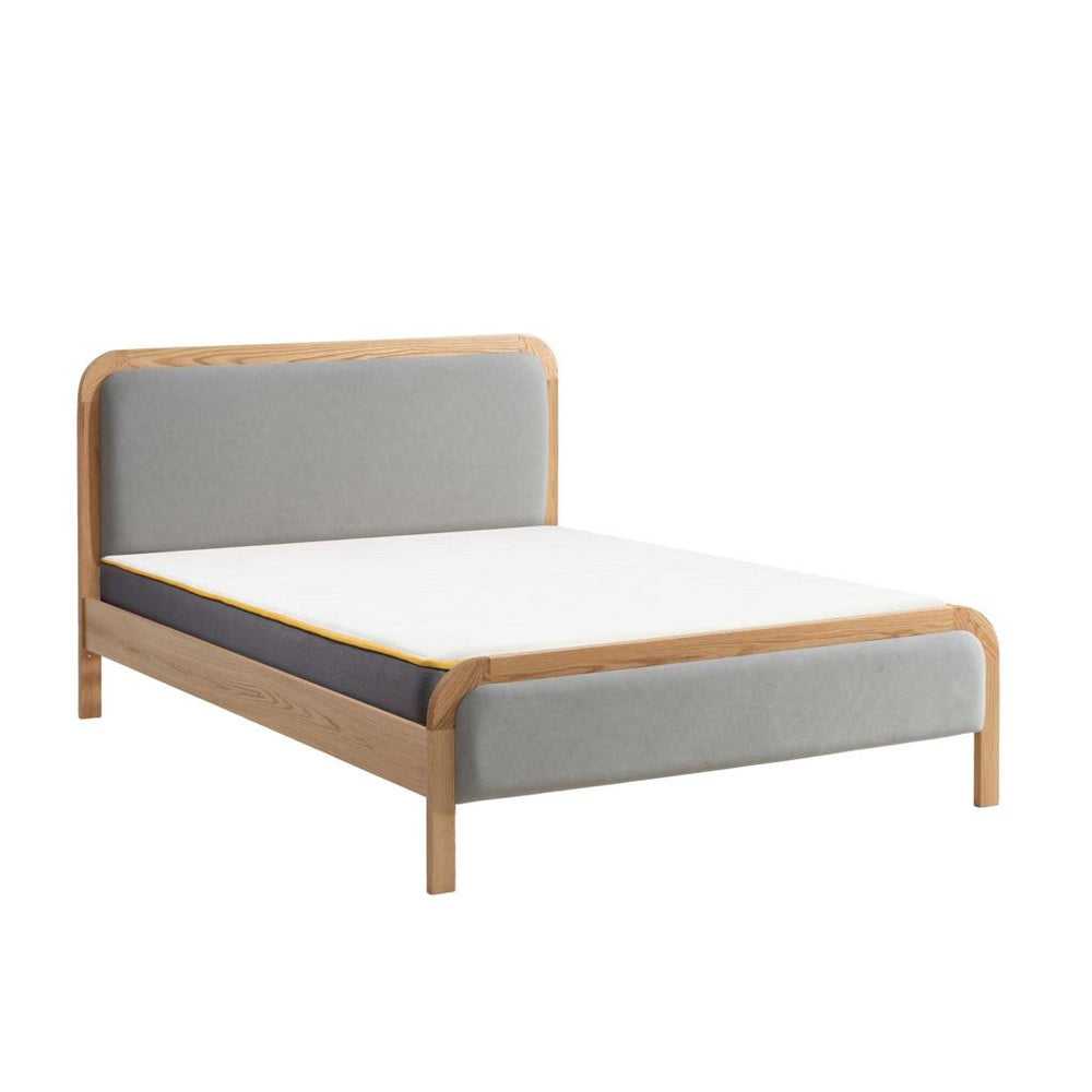 Wood and grey fabric bed frame with mattress on white background
