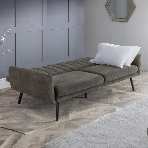 Grey sofa bed in a room with a gray wall and wooden floor.
