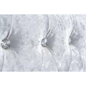 Silver tufted headboard with decorative buttons on a white background