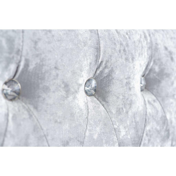 Silver tufted headboard with decorative buttons on a white background