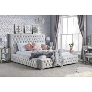 Decorative bedroom with a tufted bed, side tables, and wall art.