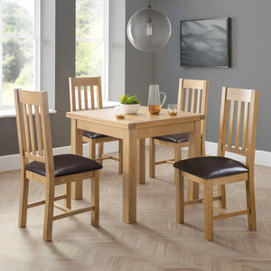 Dining room with wooden table and chairs against a gray wall.