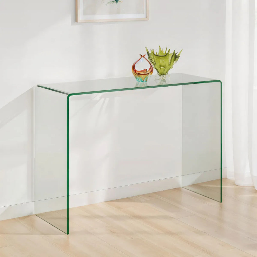 Clear glass side table with colorful glass bowls on a white background