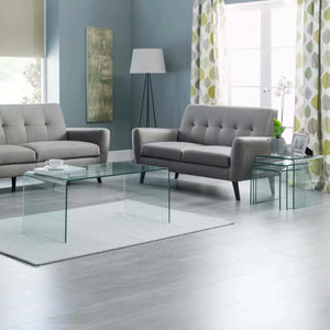 Modern living room with gray sofas, glass coffee table, and decorative elements.