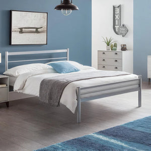 Bedroom with a metal bed frame, white bedding, and blue accents.