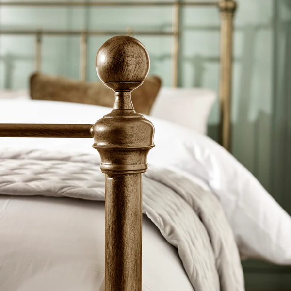 Close-up of a wooden bedpost with a blurred background