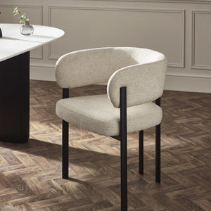 Modern chair with beige cushioned seat and backrest on a wooden floor.