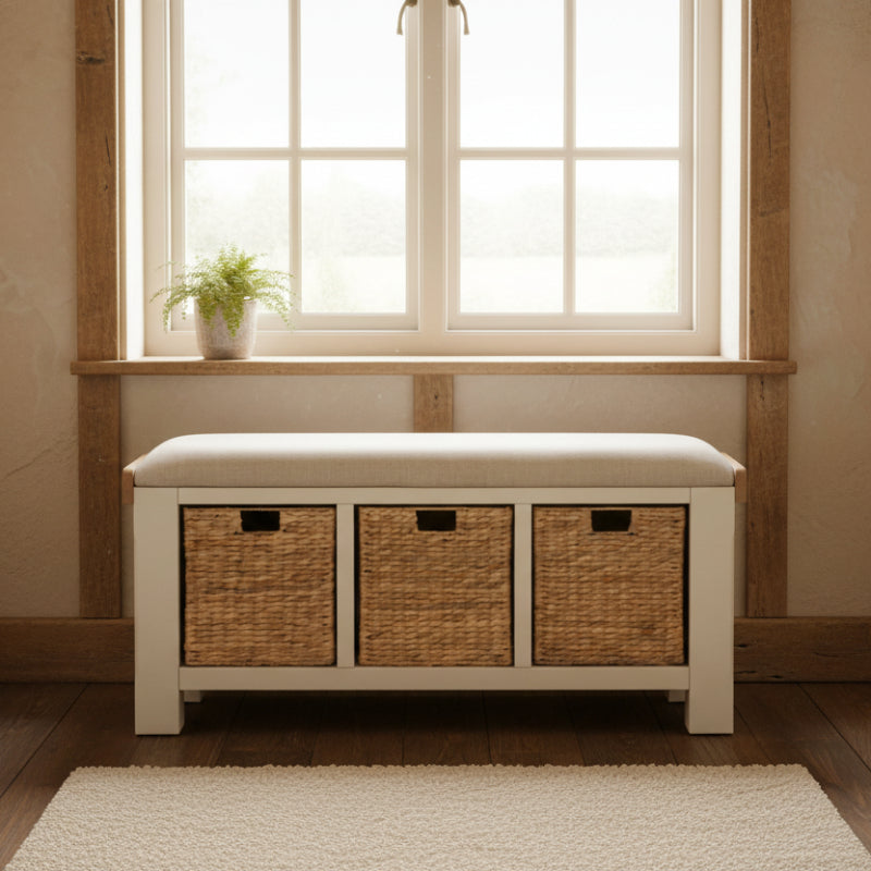 White storage bench with three wicker basket compartments on a white background
