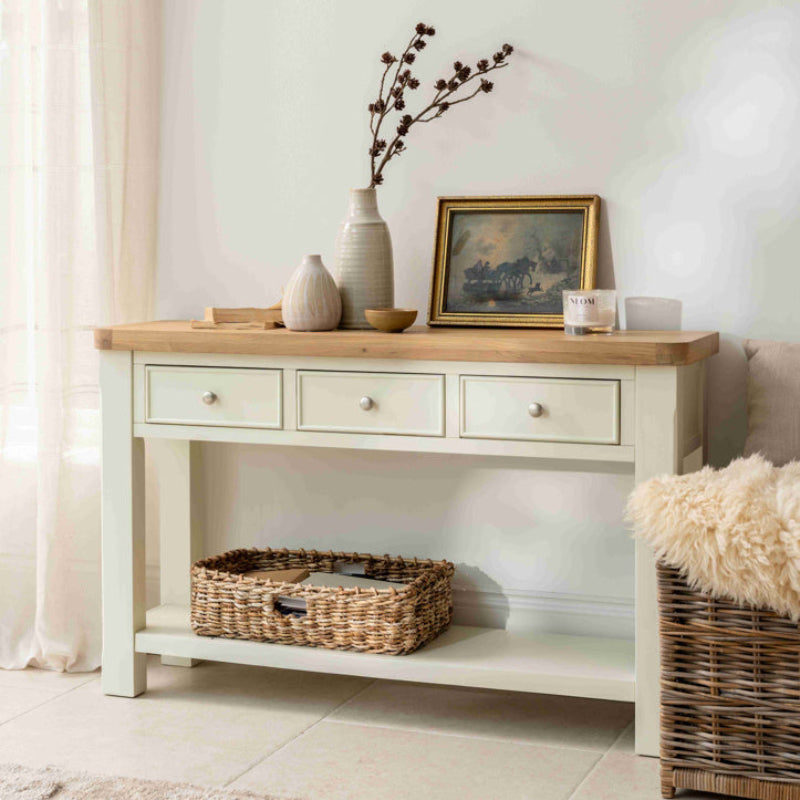 Wooden console table with three drawers on a white background