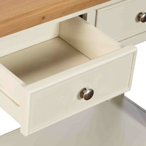 Open drawer of a wooden furniture piece with a metal handle.