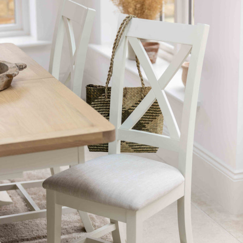 White wooden chair with a cushioned seat on a white background