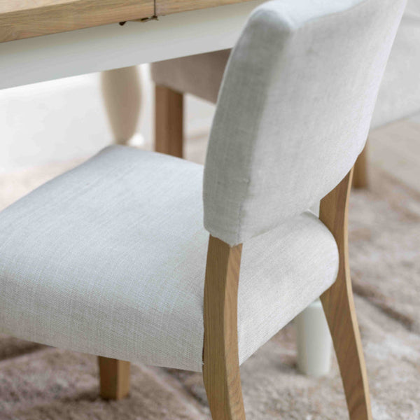 Light wooden dining table with a chair on a textured rug