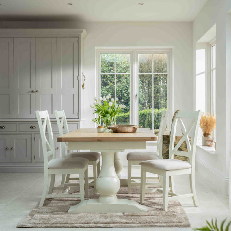 Dining table with wooden top and white base on a white background