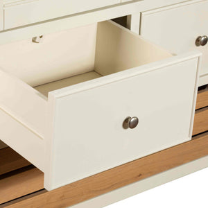 Close-up of a white drawer with wooden accents on a piece of furniture.