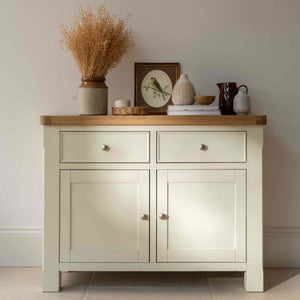 Light wooden sideboard with decorative items against a plain wall