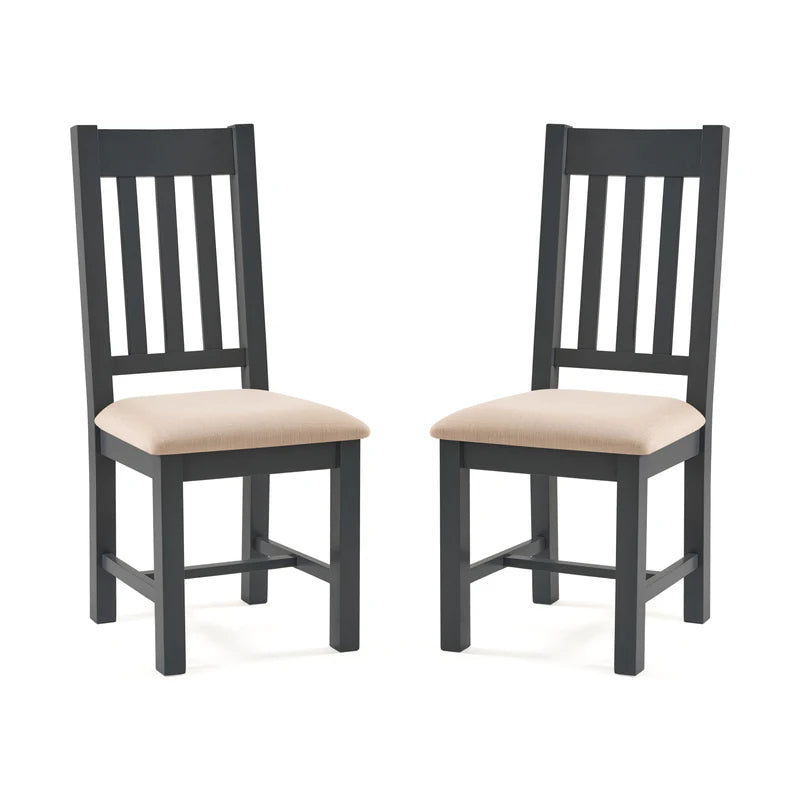 Two grey wooden chairs with beige cushioned seats on a white background