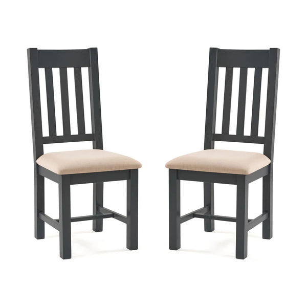 Two grey wooden chairs with beige cushioned seats on a white background