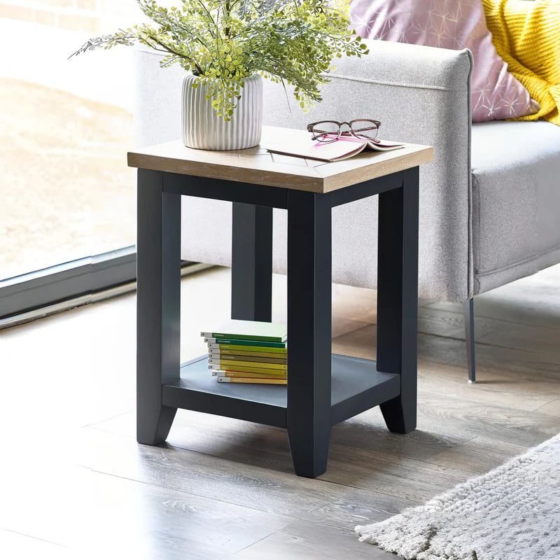 Small square table with a wooden top and dark gray base on a white background