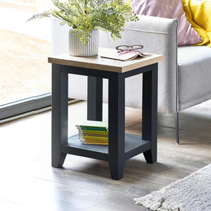 Small side table with a plant, books, and glasses in a living room setting.