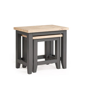 Set of two nesting tables with one having a light wood top and the other a dark gray base.