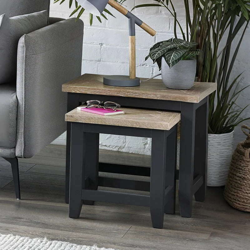 Set of two nesting tables with wooden tops and black frames on a white background