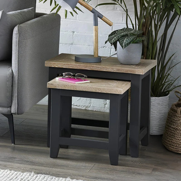 Side table with wooden top and black base in a living room setting